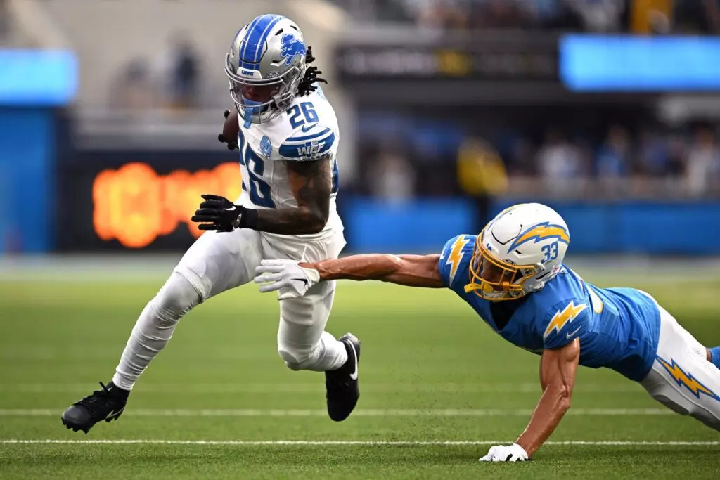 Detroit Lions running back Jahmyr Gibbs (26) runs the ball past Los Angeles cornerback Deane Leonard (33).
