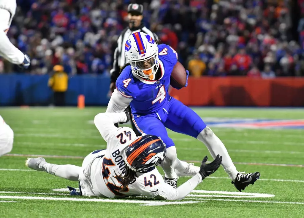 Nov 13, 2023; Orchard Park, New York, USA; Buffalo Bills running back James Cook (4) tries to break a tackle by Denver Broncos linebacker Nik Bonitto (42) in the fourth quarter at Highmark Stadium. Mandatory Credit: Mark Konezny-USA TODAY Sports