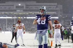 Home 13 Kansas State Wildcats quarterback Will Howard (18) in a purple jersey celebrates a touchdown in the third quarter in a snow game in Manhattan, Kansas.