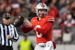 Home 9 Kyle McCord steps back to throw against Minnesota. McCord is in the red jerseys with silver helmets.