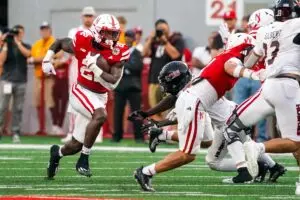 Home 8 Nebraska Cornhuskers running back Gabe Ervin Jr running down the field, avoiding Northern Illinois defenders at Memorial Stadium.