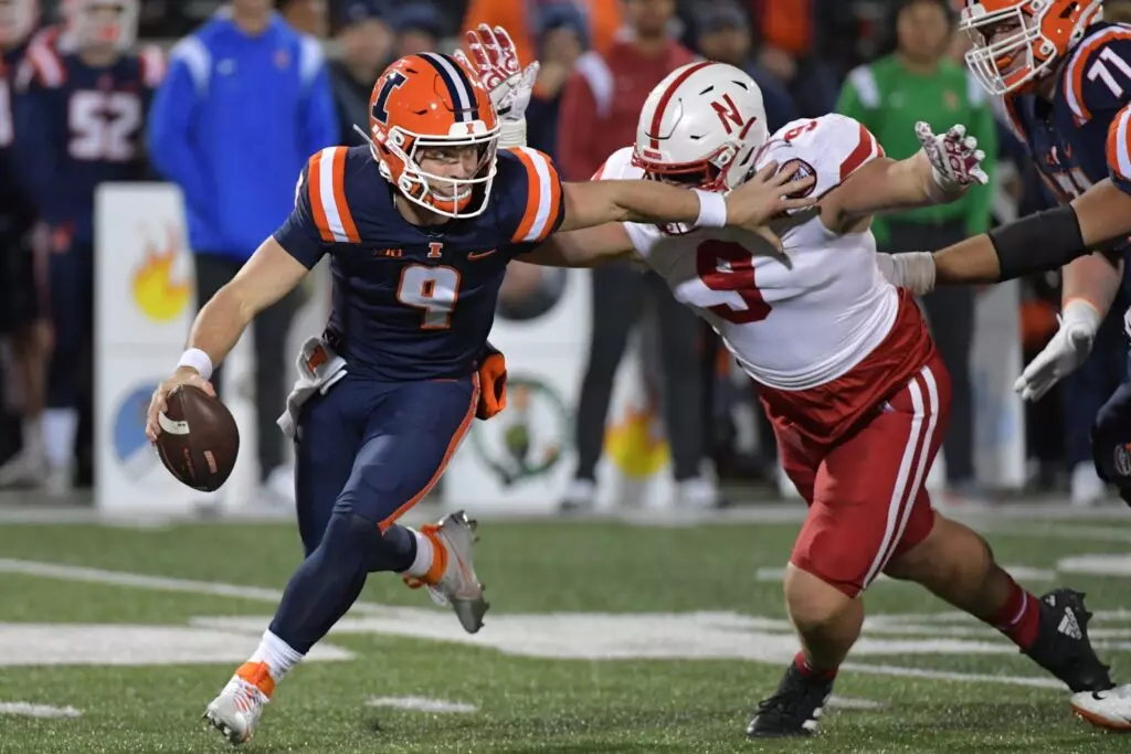 Oct 6, 2023; Champaign, Illinois, USA; Illinois Fighting Illini quarterback Luke Altmyer (9) is pursued by Nebraska Cornhuskers defensive lineman Ty Robinson (9) during the second half at Memorial Stadium. Mandatory Credit: Ron Johnson-USA TODAY Sports