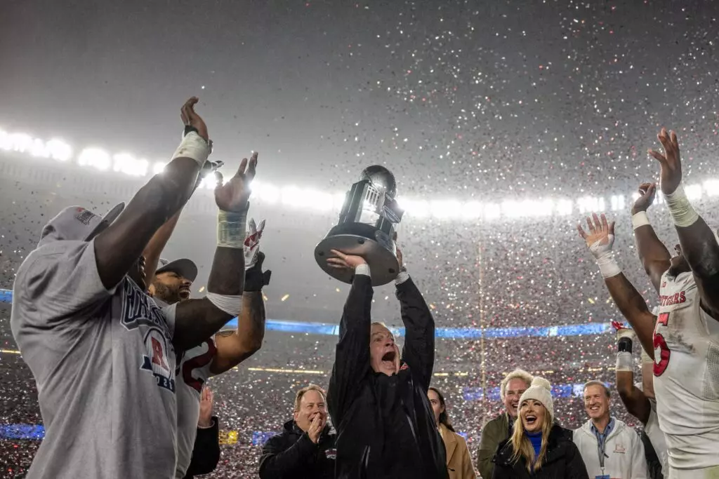 Rutgers Scarlet Knights head coach Greg Schiano lifts the trophy with Rutgers Scarlet Knights running back Kyle Monangai (5) and Rutgers Scarlet Knights quarterback Gavin Wimsatt (left) to celebrate the win against the Miami Hurricanes at Yankee Stadium.