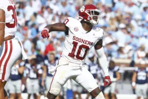 Home 15 Oklahoma Sooners linebacker (white jersey, red helmet, white pants) Kip Lewis celebrates a tackle against the Ole Miss Rebels.