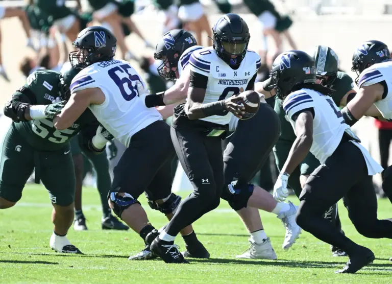 Home 1 Big Ten and Northwestern quarterback Aidan Chiles rolls back with the ball.